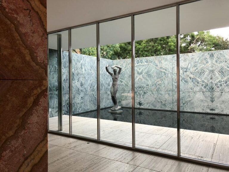 View of a modernist sculpture at the iconic Barcelona Pavilion with marble walls.