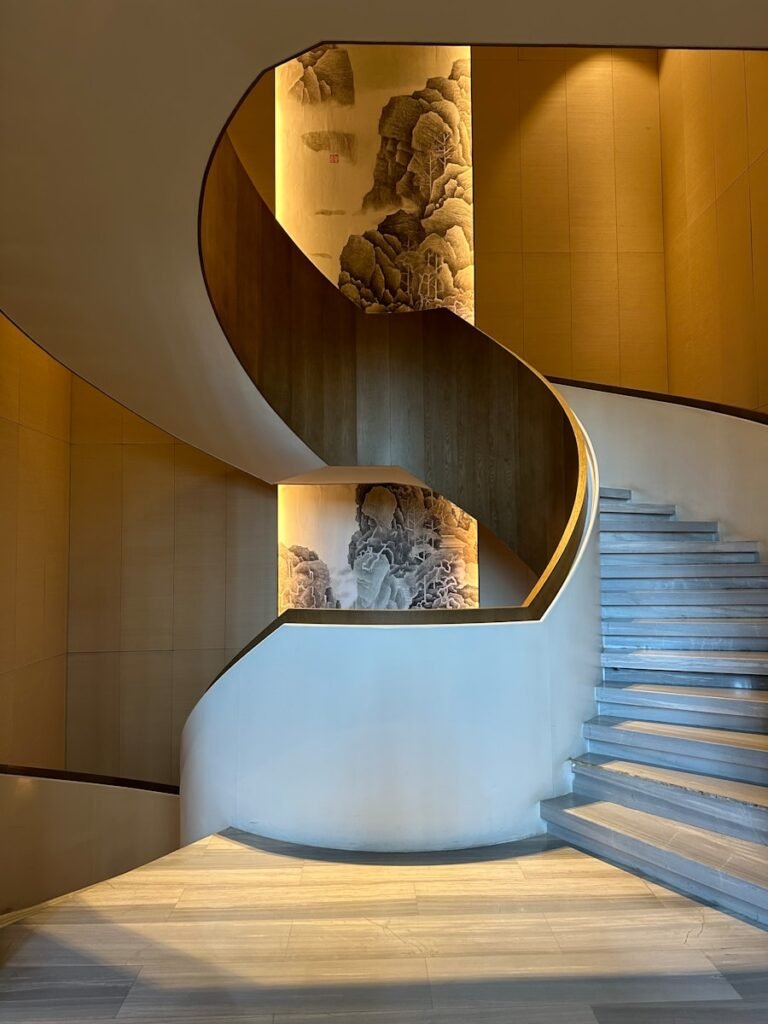 a spiral staircase in a building with a painting on the wall